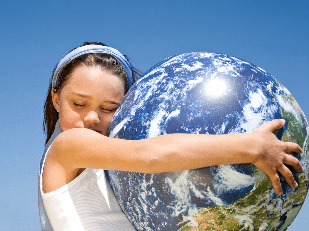 Young girl hugs a planet earth ball.